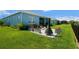 Spacious backyard with landscaped patio, modern fire feature, and tranquil lake views at 4407 Big Woods Way, Parrish, FL 34219