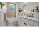 Bright bathroom features a tub and shower with a modern single sink vanity and decorative accents at 4407 Big Woods Way, Parrish, FL 34219