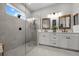 Modern bathroom features a glass-enclosed shower, dual vanity sinks, and neutral color scheme at 4407 Big Woods Way, Parrish, FL 34219