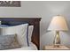 Comfortable bedroom with decorative pillows, dark wood headboard, bedside lamps, and neutral color scheme at 4407 Big Woods Way, Parrish, FL 34219