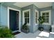 Stylish entryway featuring a navy blue front door, shuttered windows, and decorative greenery at 4407 Big Woods Way, Parrish, FL 34219