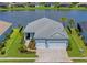 Beautiful blue home with a gray roof, two-car garage, and a picturesque lake view in the backyard at 4407 Big Woods Way, Parrish, FL 34219