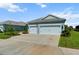 Home featuring a spacious driveway and a two-car garage, lush green lawn, and beautiful landscaping at 4407 Big Woods Way, Parrish, FL 34219