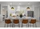 Stylish white kitchen featuring pendant lights, large island with seating, and stainless steel appliances at 4407 Big Woods Way, Parrish, FL 34219
