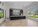 Modern kitchenette with a center island, stylish backsplash, stainless steel appliances, and large windows with natural light at 4407 Big Woods Way, Parrish, FL 34219