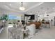 Open-concept living area with comfortable seating, a modern kitchen, and scenic lake views through sliding glass doors at 4407 Big Woods Way, Parrish, FL 34219