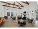 Spacious lounge area with high ceilings, exposed beams, a fireplace, and various seating arrangements and tile flooring at 4407 Big Woods Way, Parrish, FL 34219