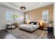 Serene main bedroom showcasing tray ceilings, a textured accent wall, and natural light from shuttered windows at 4407 Big Woods Way, Parrish, FL 34219