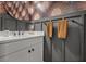 Stylish powder room featuring decorative wallpaper, paneled accent wall, and modern fixtures at 4407 Big Woods Way, Parrish, FL 34219