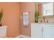 Bathroom featuring peach walls, a white vanity with marble countertop, gold faucet, and an ornate mirror at 4475 Sandner Dr, Sarasota, FL 34243