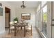 Dining room with rustic table set for a meal, a modern light fixture, and ample natural light at 4475 Sandner Dr, Sarasota, FL 34243