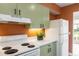 Cozy kitchen featuring light green cabinetry and white appliances at 4475 Sandner Dr, Sarasota, FL 34243