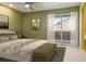 A bedroom with a view to the balcony, a queen bed, and green walls at 4475 Sandner Dr, Sarasota, FL 34243