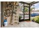 Screened patio with neutral tile flooring, ladder, bikes and outdoor views at 4475 Sandner Dr, Sarasota, FL 34243