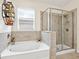 This bathroom features a soaking tub with tile surround, and a glass enclosed walk-in shower with tile surround at 4615 73Rd E St, Bradenton, FL 34203