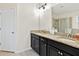 This primary bathroom features dual sinks, granite countertops, black cabinets, and a shower with glass doors at 4615 73Rd E St, Bradenton, FL 34203