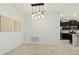 Dining area with modern light fixture adjacent to open kitchen featuring tile flooring and white walls at 4615 73Rd E St, Bradenton, FL 34203