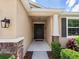 Inviting entryway with a dark front door, stone accents, and lush greenery at 4615 73Rd E St, Bradenton, FL 34203