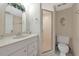 Well-lit bathroom features a vanity with a sink, mirror, and a glass-enclosed shower at 4650 Ringwood Meadow # 37, Sarasota, FL 34235
