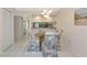 Open dining area showcasing a round glass table, unique chairs, and access to a hallway and the kitchen at 4650 Ringwood Meadow # 37, Sarasota, FL 34235