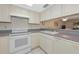 Bright kitchen with white cabinets and appliances and a pass through to the dining area at 4650 Ringwood Meadow # 37, Sarasota, FL 34235
