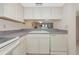 Bright kitchen with white cabinets and appliances and a pass through to the dining area at 4650 Ringwood Meadow # 37, Sarasota, FL 34235