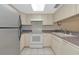 Well-lit kitchen featuring white appliances, cabinets, tile floors, and a convenient breakfast bar at 4650 Ringwood Meadow # 37, Sarasota, FL 34235