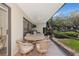 Outdoor patio with dining area, fan, and views of a manicured lawn at 4650 Ringwood Meadow # 37, Sarasota, FL 34235