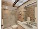 Bathroom with sliding glass shower doors and a vintage patterned wallpaper at 4917 Leatha Ln, Sarasota, FL 34232