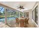 Covered outdoor patio with wicker furniture next to a screened in pool overlooking a wooded backyard at 4917 Leatha Ln, Sarasota, FL 34232