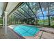 Screened pool area with a diving board, mature landscaping, and scenic water view is perfect for recreation and relaxation at 4917 Leatha Ln, Sarasota, FL 34232