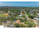 Expansive aerial view of a coastal community showcasing lush landscaping and the Gulf of Mexico on the horizon at 5223 Shadow Lawn Dr, Sarasota, FL 34242