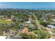 Expansive aerial view of a coastal community showcasing lush landscaping and the Gulf of Mexico on the horizon at 5223 Shadow Lawn Dr, Sarasota, FL 34242