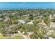 Breathtaking aerial view of a waterfront neighborhood with lush greenery and stunning ocean views in the distance at 5223 Shadow Lawn Dr, Sarasota, FL 34242
