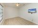 Bright bedroom with wood floors, ceiling fan, and a wall mounted television at 5223 Shadow Lawn Dr, Sarasota, FL 34242