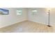 This bedroom features updated flooring, baseboards, and two windows at 5223 Shadow Lawn Dr, Sarasota, FL 34242