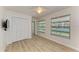 Bedroom with wood floors, ceiling fan, closet, and a view of the pool at 5223 Shadow Lawn Dr, Sarasota, FL 34242