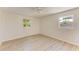 A bedroom with new flooring and two windows allowing for plenty of natural light at 5223 Shadow Lawn Dr, Sarasota, FL 34242