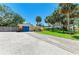 Charming yellow single-story home with a blue garage door and nice landscaping at 5223 Shadow Lawn Dr, Sarasota, FL 34242
