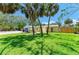 Charming yellow home with a well-manicured lawn and mature palm trees in the front yard at 5223 Shadow Lawn Dr, Sarasota, FL 34242