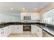 Updated kitchen featuring modern appliances, granite countertops, and white cabinetry at 5223 Shadow Lawn Dr, Sarasota, FL 34242