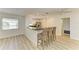 Open concept kitchen with breakfast bar, wicker stools, stainless steel appliances, and modern finishes at 5223 Shadow Lawn Dr, Sarasota, FL 34242