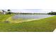 Scenic backyard view of a lush grassy lawn leading to a serene lake, surrounded by beautiful homes in the community at 5224 58Th E Ter, Bradenton, FL 34203