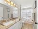 Well-lit bathroom featuring double sinks with granite countertops and a shower and tub combination at 5224 58Th E Ter, Bradenton, FL 34203