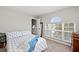 Bright bedroom with a large window, patterned bedding, and a full-length mirror at 5224 58Th E Ter, Bradenton, FL 34203