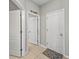 Hallway with neutral toned walls, tile flooring, and white doors at 5224 58Th E Ter, Bradenton, FL 34203
