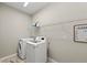 Laundry room with a washer, dryer, and laundry supplies on a shelf at 5224 58Th E Ter, Bradenton, FL 34203