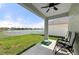 Covered patio area overlooking a fenced backyard with a lake view at 5224 58Th E Ter, Bradenton, FL 34203