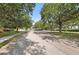 A view of the tree-lined street with a glimpse of the community entrance, showcasing the peaceful and inviting atmosphere at 5224 58Th E Ter, Bradenton, FL 34203