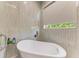 Bright bathroom featuring a modern soaking tub, stylish tile, and a large window, creating a spa-like atmosphere at 5319 120Th E Ave, Parrish, FL 34219